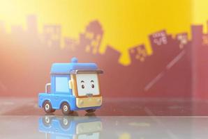 blauwe cartoon auto speelgoed selectieve focus op wazige stadsachtergrond foto