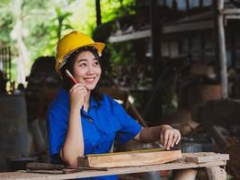 vrouw die in mechanisch uniform werkt en meetinstrumenten gebruikt om houten platen in de fabriek te snijden foto