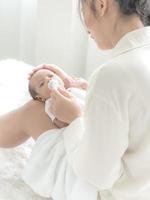 een mooie Aziatische vrouw legt haar pasgeboren baby op haar lichaam foto
