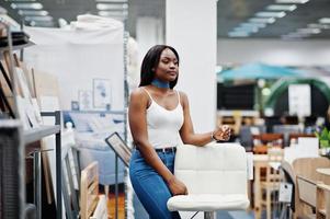 portret van een fantastische vrouw met Afro-Amerikaanse afkomst die in de winkel loopt. foto