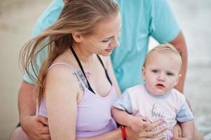 zomervakanties. ouders en mensen buitenactiviteiten met kinderen. fijne familievakanties. vader, zwangere moeder, dochtertje op zee zandstrand. foto