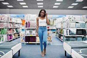 portret van een fantastische vrouw met Afro-Amerikaanse afkomst die in de winkel loopt. foto