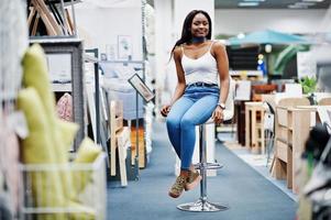 portret van een mooie Afro-Amerikaanse vrouw die in de winkel zit. foto