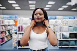 portret van een fantastische vrouw met Afro-Amerikaanse afkomst die in de winkel loopt. foto