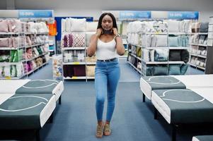 portret van een fantastische vrouw met Afro-Amerikaanse afkomst die in de winkel loopt. foto