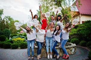 gezelschap van jonge vrouwen die buiten poseren met opgeblazen condooms op vrijgezellenfeest. foto