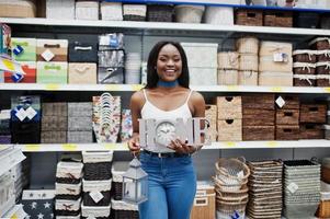 portret van een mooie Afro-Amerikaanse vrouw met een huisbord en een blakerfakkel in de winkel. foto