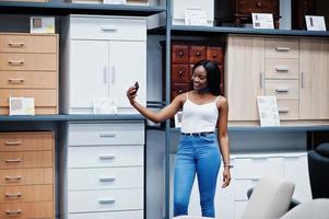 portret van een mooie Afro-Amerikaanse vrouw die een selfie neemt in de winkel. foto