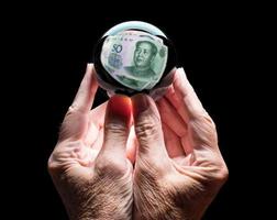 handen met een voorspellingsbal van kristalglas die het hoofd weerspiegelt op een Chinese rekening van 50 yuan foto