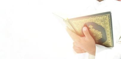 man die de koran vasthoudt en leest. islamitische achtergrond foto