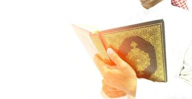 man die de koran vasthoudt en leest. islamitische achtergrond foto