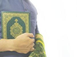 man die de koran vasthoudt en leest. islamitische achtergrond foto