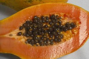 halve snede van verse rijpe papaya met zaden geïsoleerd op een witte achtergrond. selectieve aandacht. foto