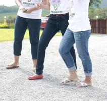 de benen van drie vrouwen die op de weg lopen foto