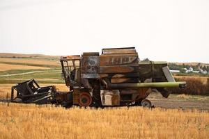 ontmantelde roestige maaidorser in een veld in Saskatchewan foto