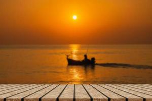 lege houten tafel op prachtige wazige zee zonsondergang foto