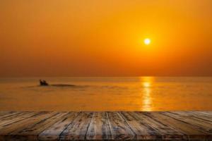 lege houten tafel op prachtige wazige zee zonsondergang foto