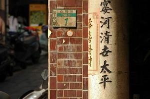 chinese letters op oude bakstenen muur in taiwan foto