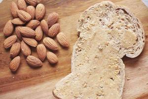 amandelboter op een bruin brood op tafel foto