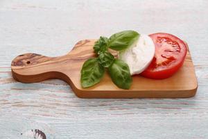 basilicumblad, mozzarella kaas en plakje tomaat foto