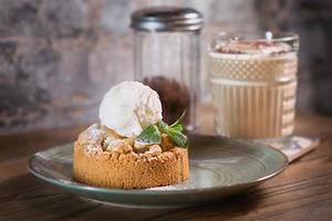 Apfelstrudel met ijs en munt op het bord en cocktail van witte melk op tafel foto