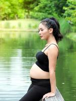 mooie zwangere vrouwen zitten in het park en ontspannen met lichaamsbeweging voor een goede gezondheid foto