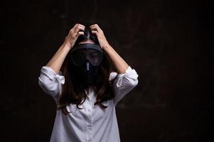 gestresste Aziatische vrouwen moeten een gasmasker gebruiken om stofvervuiling te voorkomen en infectie door virussen te voorkomen die zich in de lucht verspreiden foto