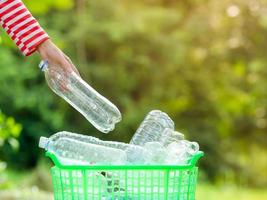 vrijwillige vrouwen verzamelen plastic waterflessen in het park foto