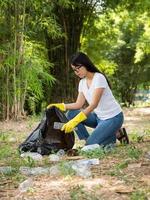 vrijwillige vrouwen verzamelen plastic waterflessen in het park foto