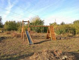 houten glijbaan en schommels voor kinderen voor de tuin. foto