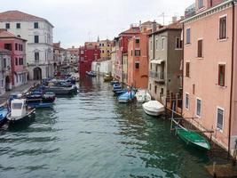 haven van chioggia met kleine boten in de buurt van kleurrijke gebouwen foto