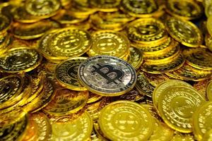gouden bitcoin cryptocurrency op stapel gouden munten veel foto