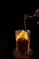 barman bereidt cuba libre cocktail in een hoog glas