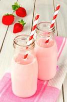 aardbeienmelk in flessen op tafel foto