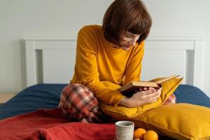 taille portret van mooie volwassen vrouw leesboek. gezellig altijd ontspannen foto