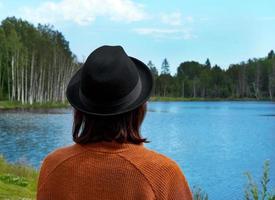 achteraanzicht van brunette dame kijkend naar meer in karelia foto