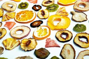 biologische gezonde geassorteerde gedroogde fruitmix close-up. gedroogd fruit tussendoortjes. gedroogde appels, mango, feijoa, gedroogde abrikozen, pruimen bovenaanzicht foto