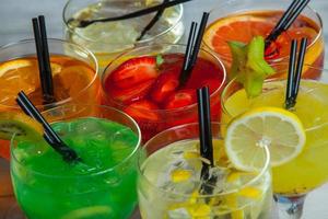 verschillende alcoholische cocktails op witte achtergrond. kleurrijke cocktails close-up. vruchtensap cocktaildrank. diverse cocktaildrankjes. glazen vruchtendranken met ijsblokjes op tafel in café foto