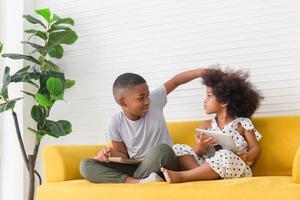 kinderen broer en zus spelen samen in de woonkamer, kinderen jongen en meisje hebben plezier thuis foto