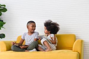 kinderen broer en zus spelen samen in de woonkamer, kinderen jongen en meisje hebben plezier thuis foto