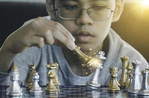 geconcentreerde serieuze jongen die schaakgambiet, strategie ontwikkelt, bordspel speelt tot winnaar slimme concentratie en denkend kind tijdens het schaken. leren, tactiek en analyse concept. foto