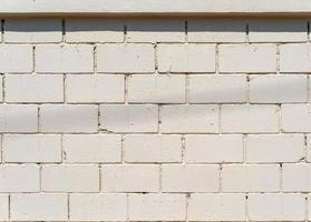 wit-crème cement muur met baksteen patroon op buiten veld voor achtergrond. foto
