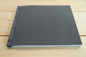 klassiek zwart notitieboekje op de houten tafel. foto