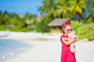 schattig klein meisje speelt met speelgoed tijdens strandvakantie foto