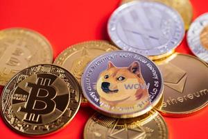 dogecoin doge-groep inbegrepen bij cryptocurrency-munt bitcoin, ethereum eth, bitcoin cash bch, ethereum classic enz. symbool virtuele blockchain-technologie toekomst is geld verliezen close-up op rode achtergrond foto