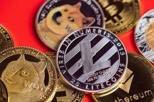 dogecoin doge groep opgenomen met cryptocurrency munt bitcoin, ethereum eth, zilveren litecoin ltc, symbool virtuele blockchain technologie toekomst is geld verliezen close-up op rode achtergrond foto