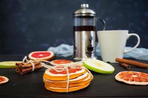 fruitthee met appel, grapefruit en kaneel op houten achtergrond foto