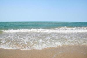 groothoek opname van zeewater dat het strand raakt, witte spons van de zee, zomer natuur achtergrond afbeelding concept. foto