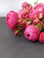 een boeket rozen op een donkergrijze tafel, een wenskaartsjabloon. een formulier met ruimte voor tekst. foto