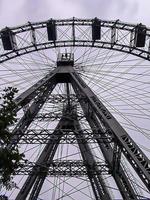 lage hoekopname van een reuzenrad tegen een bewolkte hemel in een pretpark foto